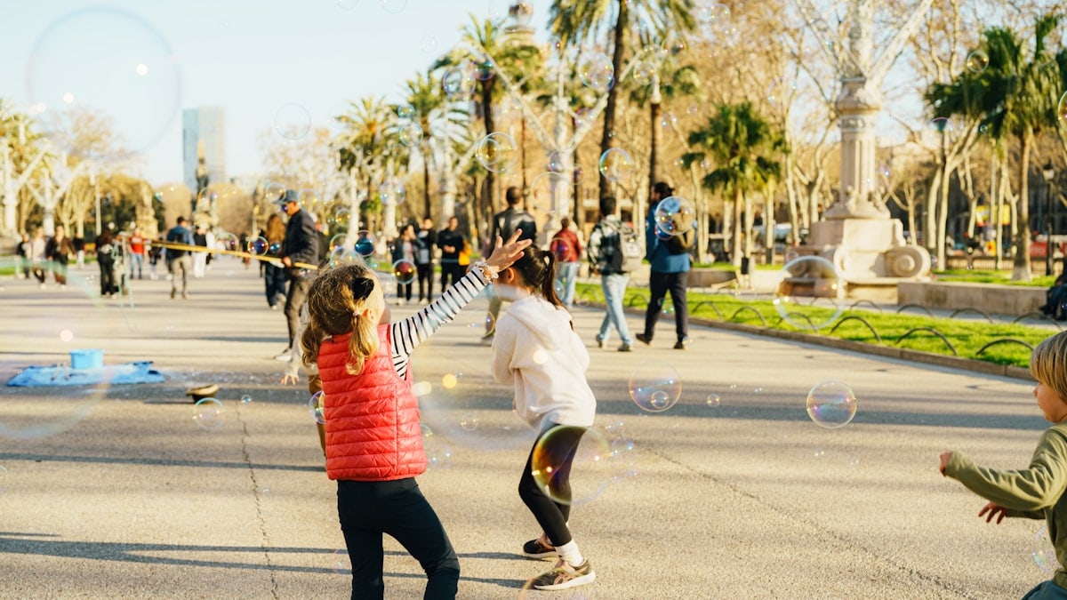 Children playing with bubbles in a park